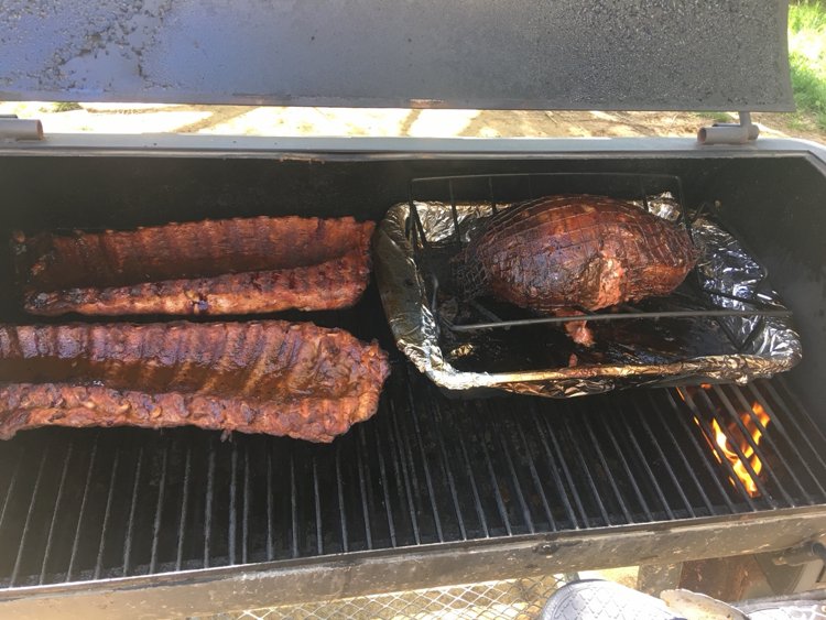Ribs and meat cooking inside the smoker